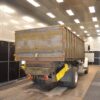 Freshly blasted truck-mounted grain and dump body inside a Kresco blast room, showing bare white metal ready for coating