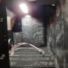 Inside a Kresco CleanBlast sandblast cabinet: full rubber lining, expanded-metal work grate, blast gun with braided hose, LED interior light and window blast shield