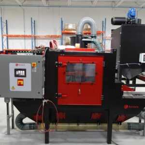 Kresco inline conveyor blast cabinet, front view: roller conveyor pass-through, touchscreen PLC control panel with emergency stop, cyclone media reclaim and cartridge dust collector